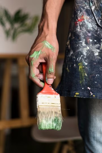 hand-holding-stained-brush_23-2148002359
